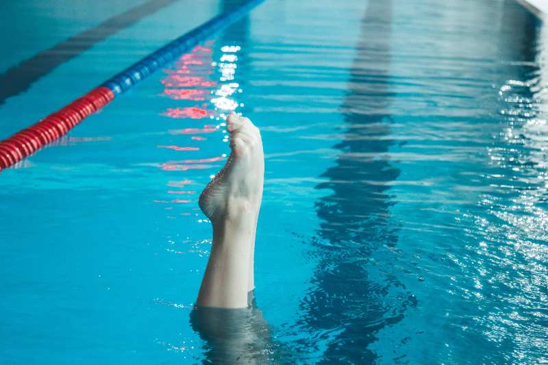 Un pie de una nadadora de sincronizada sobresale del agua