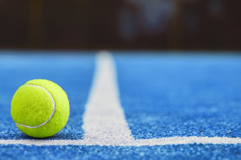 Pelota de tenis en una pista azul