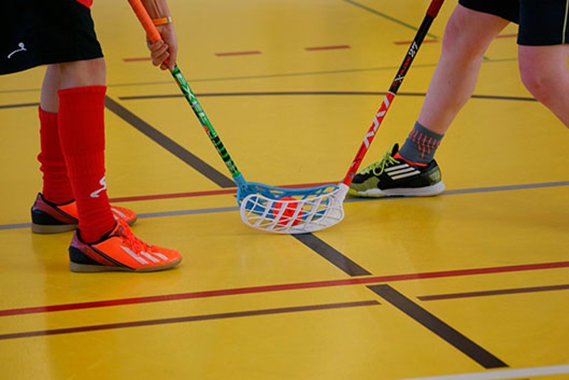 Pies de dos jugadores de Unihockey-floorball con sticks